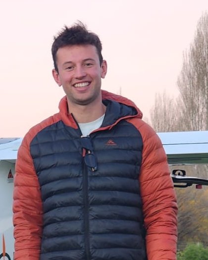 Hamish Lindsay, smiling, outdoors on a winter evening in Canterbury